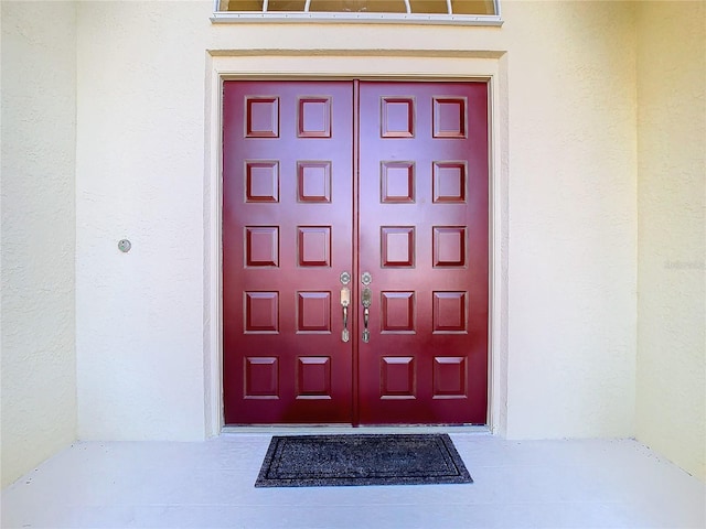 property entrance with stucco siding