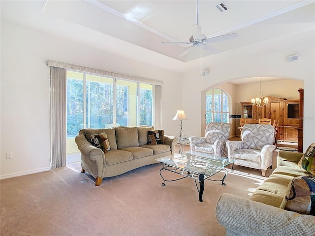 living room featuring light carpet, ceiling fan with notable chandelier, and a raised ceiling