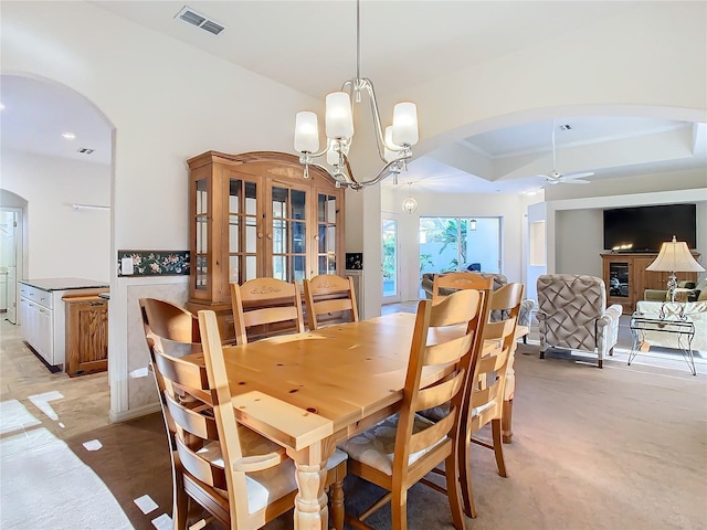 dining room featuring visible vents, a tray ceiling, ceiling fan with notable chandelier, french doors, and arched walkways