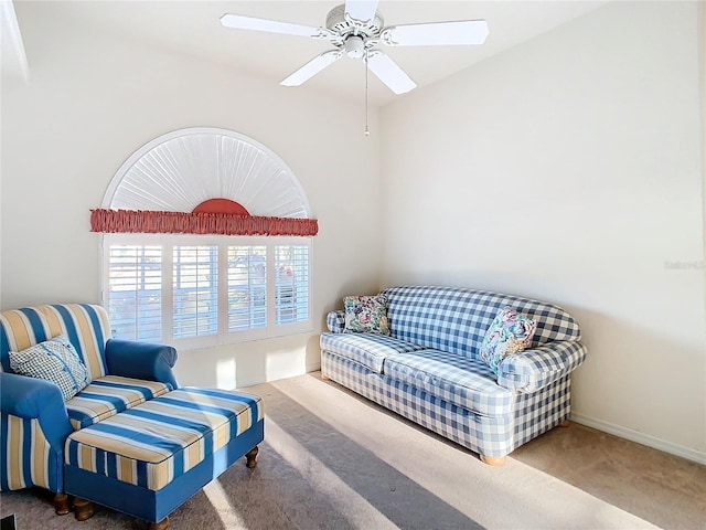 living room featuring baseboards, a ceiling fan, and carpet