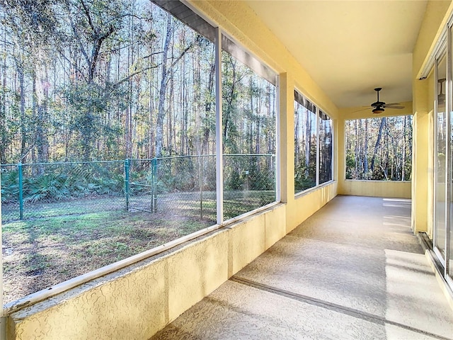 unfurnished sunroom with ceiling fan