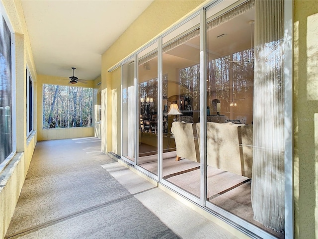 exterior space with ceiling fan and light colored carpet