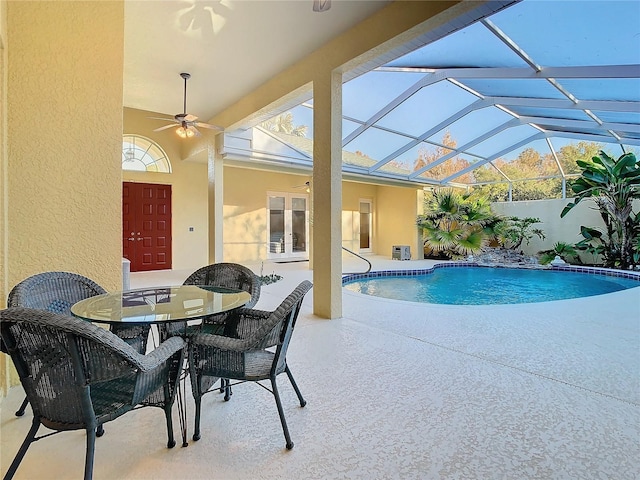 view of pool with a fenced in pool, ceiling fan, glass enclosure, french doors, and a patio