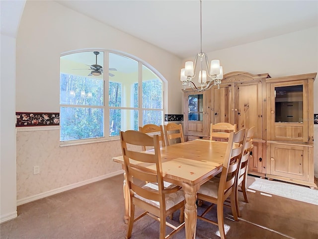 carpeted dining space with baseboards and ceiling fan with notable chandelier