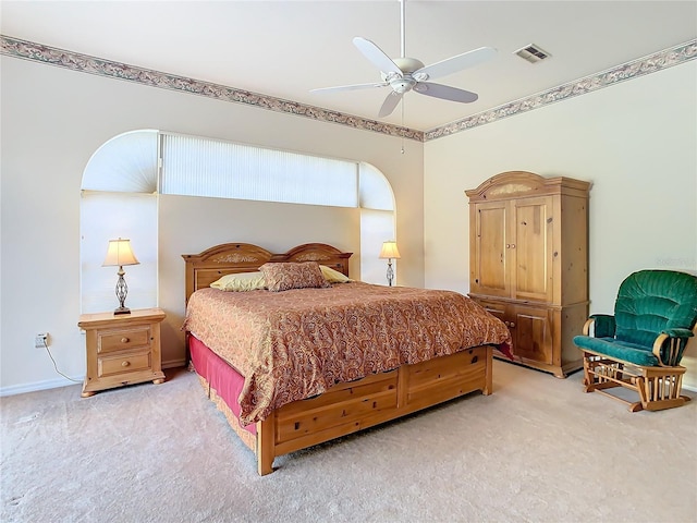 bedroom with light carpet, visible vents, and a ceiling fan