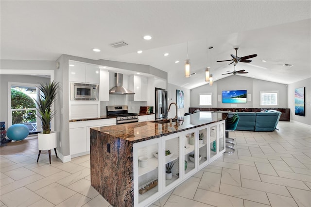 kitchen with white cabinetry, sink, wall chimney exhaust hood, stainless steel appliances, and lofted ceiling