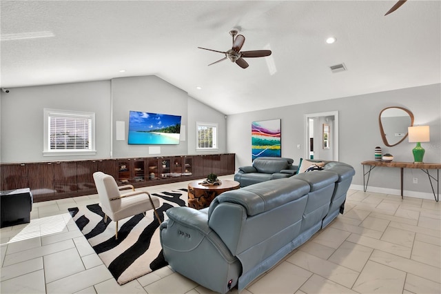 living room featuring ceiling fan, lofted ceiling, and a textured ceiling