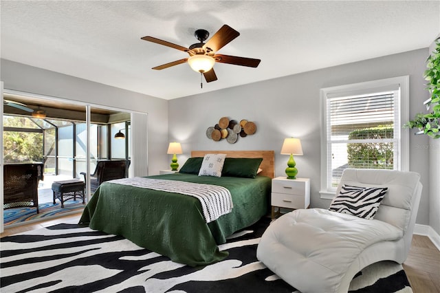 bedroom with ceiling fan, access to exterior, and a textured ceiling