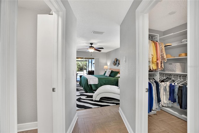 bedroom featuring a textured ceiling, light parquet floors, and ceiling fan