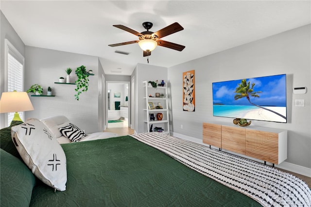 bedroom with connected bathroom, ceiling fan, and wood-type flooring