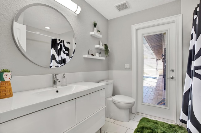 bathroom with tile patterned flooring, vanity, and toilet