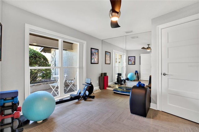 exercise area featuring ceiling fan and parquet flooring