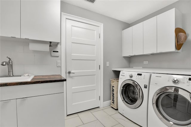 laundry room featuring cabinets, separate washer and dryer, and sink