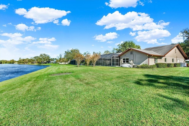 view of yard with glass enclosure and a water view