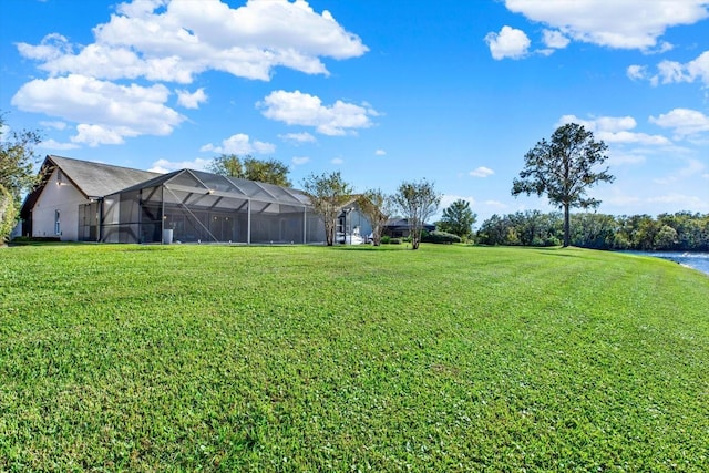 view of yard featuring a water view and glass enclosure