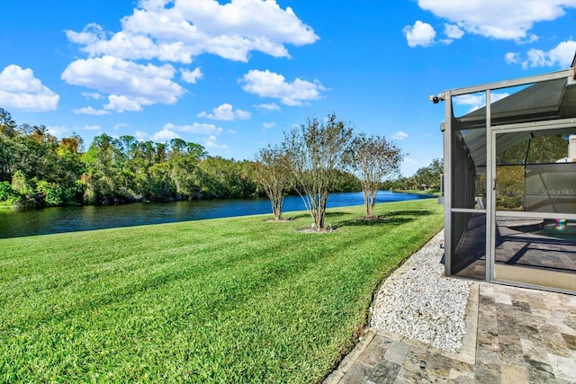 view of yard featuring a water view and glass enclosure