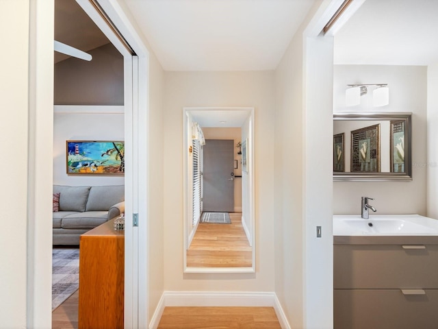 hallway featuring hardwood / wood-style flooring and sink