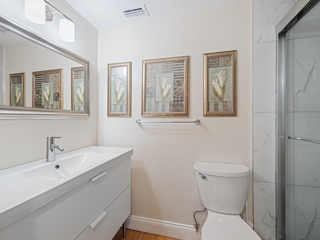 bathroom with hardwood / wood-style floors, vanity, toilet, and a shower with door