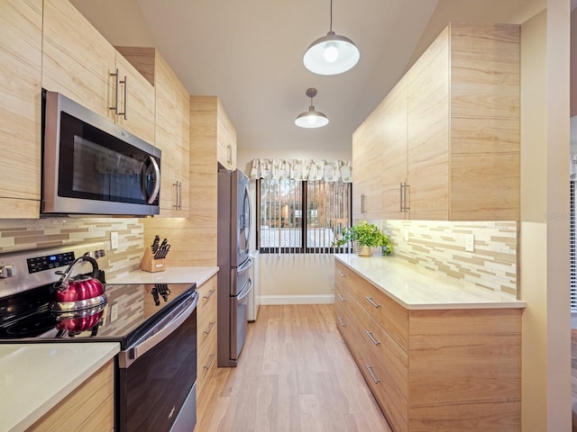 kitchen featuring pendant lighting, light brown cabinets, decorative backsplash, appliances with stainless steel finishes, and light hardwood / wood-style floors