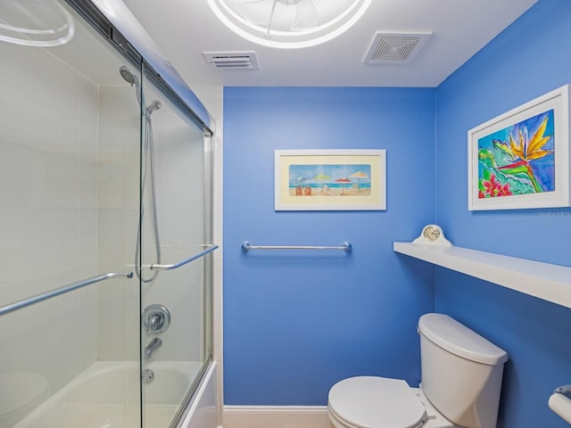 bathroom featuring toilet and enclosed tub / shower combo