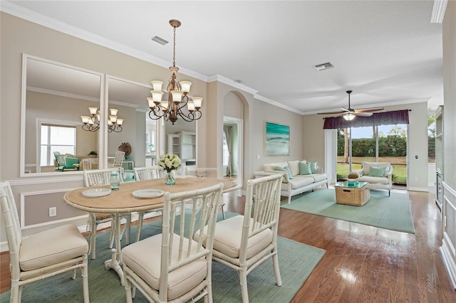 dining space with hardwood / wood-style floors, ceiling fan with notable chandelier, and ornamental molding