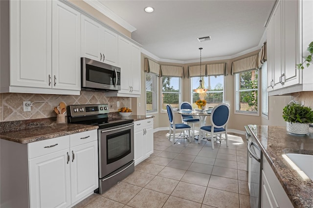 kitchen with white cabinetry, pendant lighting, and stainless steel appliances