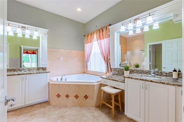 bathroom with tile patterned floors, tiled tub, and vanity