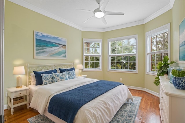 bedroom with ceiling fan, wood-type flooring, and ornamental molding