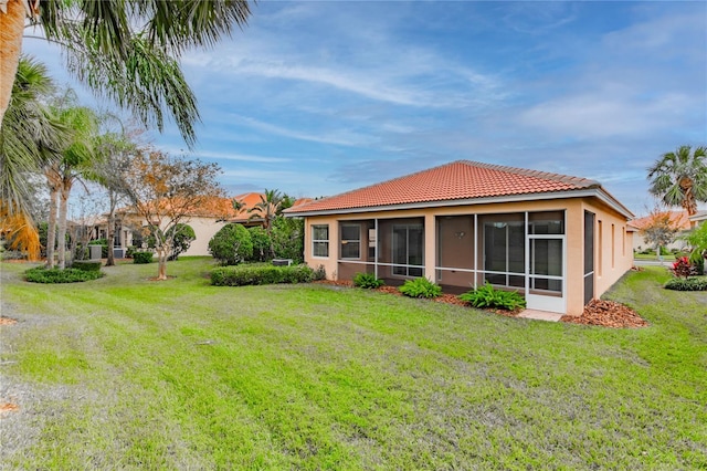 back of house featuring a sunroom and a yard