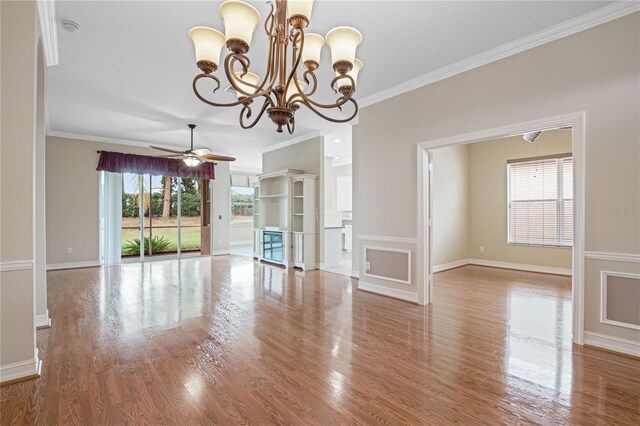 unfurnished living room with ceiling fan with notable chandelier, wood finished floors, baseboards, and ornamental molding