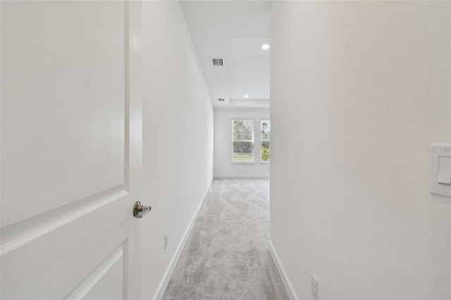 hall with light colored carpet