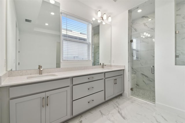 bathroom featuring vanity, a raised ceiling, and a shower with shower door