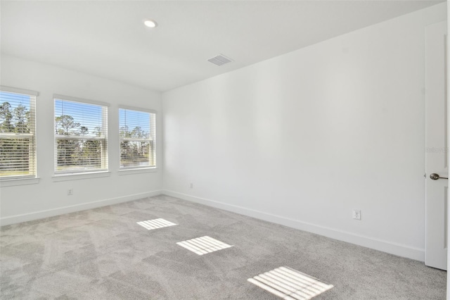 carpeted spare room featuring a healthy amount of sunlight