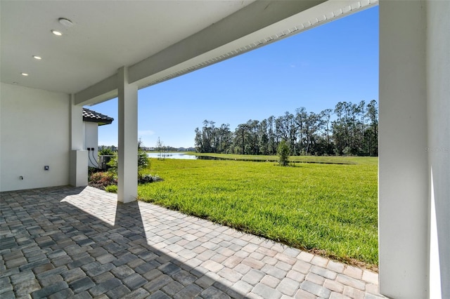 view of yard with a water view and a patio