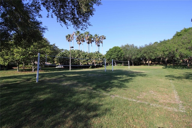 view of home's community with volleyball court and a lawn