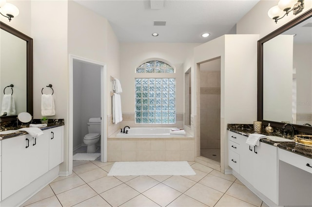 full bathroom featuring toilet, vanity, tile patterned floors, and independent shower and bath