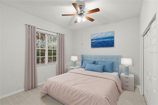 bedroom with ceiling fan, a closet, and light carpet