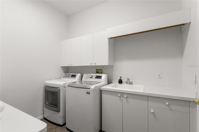 washroom featuring washer and clothes dryer, light tile patterned flooring, cabinets, and sink