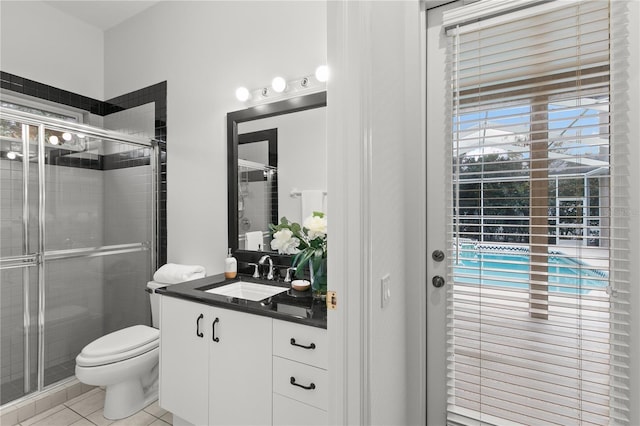 bathroom with tile patterned flooring, vanity, toilet, and a shower with door