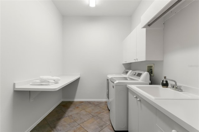 laundry area featuring cabinets, separate washer and dryer, and sink