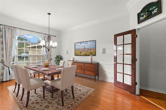 dining room featuring light hardwood / wood-style flooring, an inviting chandelier, and ornamental molding