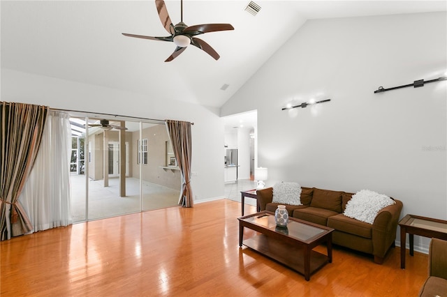 living room with light wood-type flooring, high vaulted ceiling, and ceiling fan