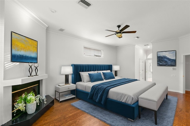 bedroom with ceiling fan, dark hardwood / wood-style floors, and ornamental molding