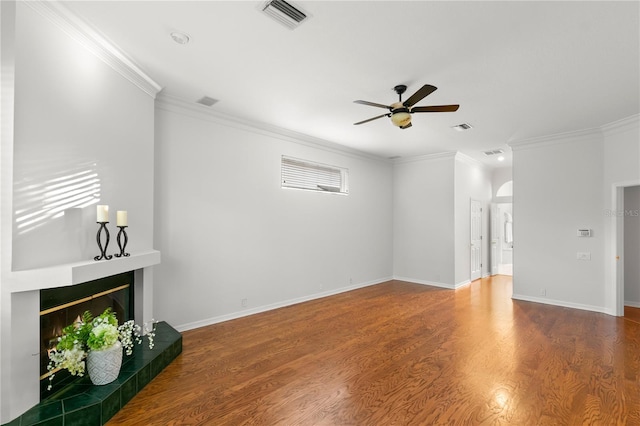 unfurnished living room featuring hardwood / wood-style flooring, ceiling fan, ornamental molding, and a tile fireplace