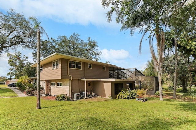 back of property featuring a lawn, glass enclosure, and central air condition unit