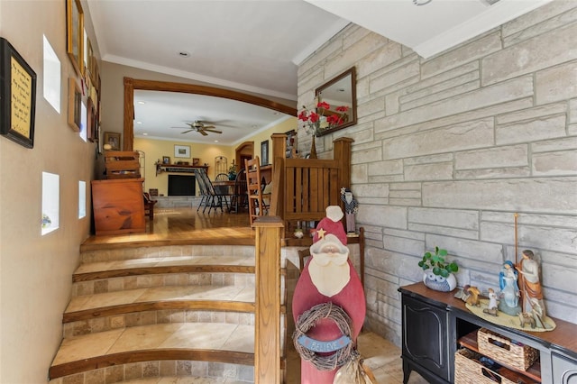 staircase with ceiling fan and ornamental molding