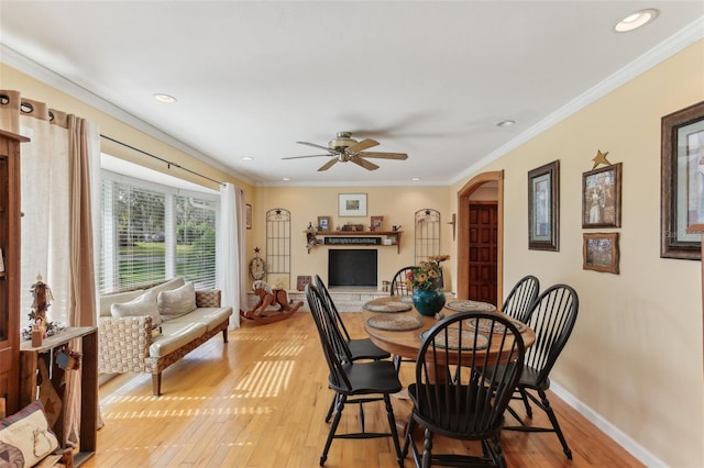 dining room with ceiling fan, crown molding, and light hardwood / wood-style floors