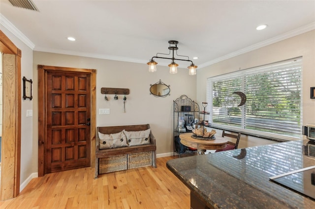 dining room with ornamental molding and light wood-type flooring