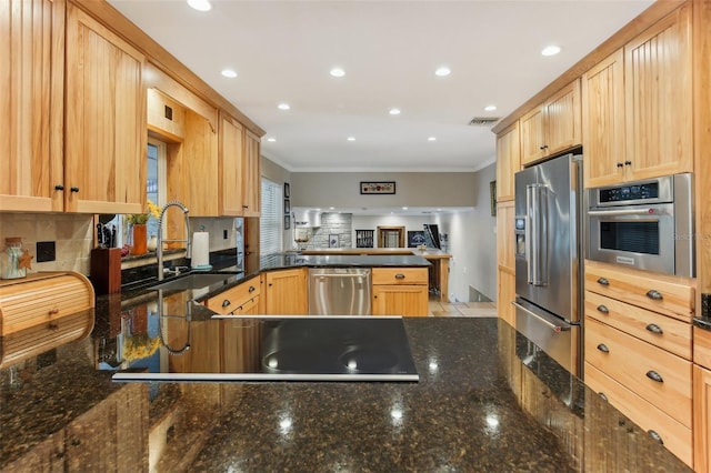 kitchen featuring dark stone countertops, crown molding, light brown cabinetry, and appliances with stainless steel finishes