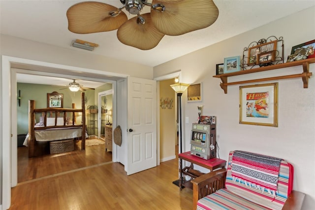 living area featuring hardwood / wood-style flooring and ceiling fan